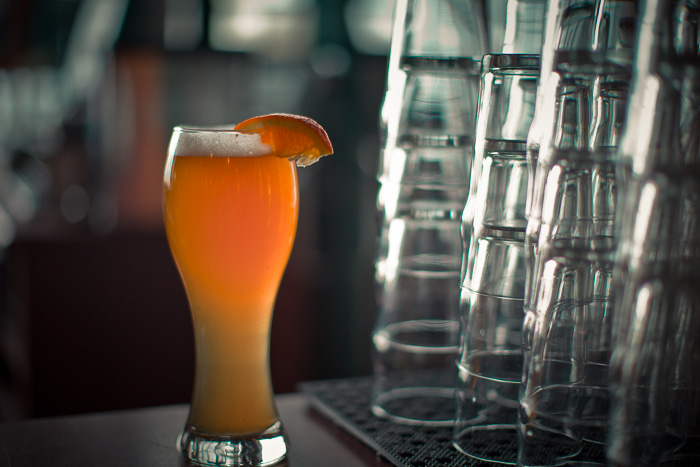 A refreshing tall glass of Orange Honey Wheat topped with a wedge of Valencia orange.